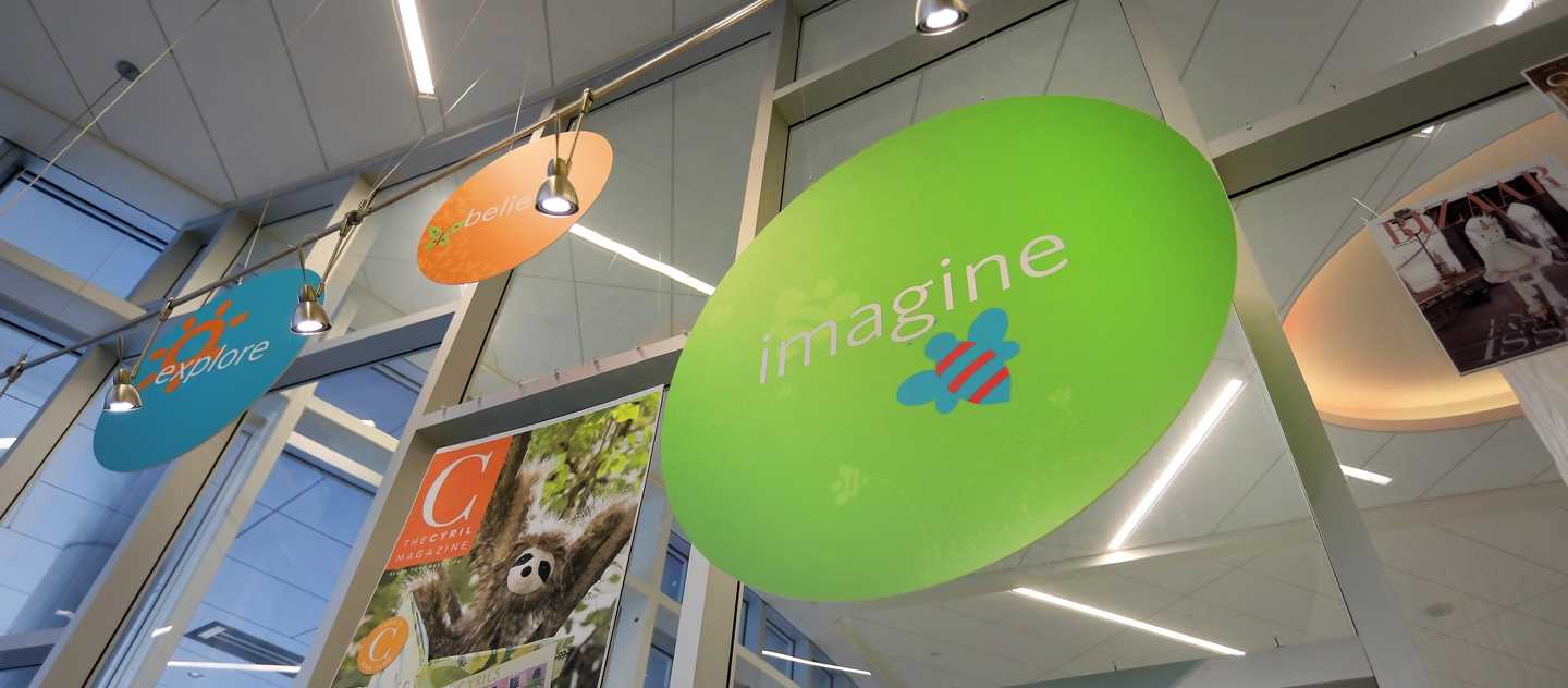 colorful gift shop signs that say explore, believe, imagine