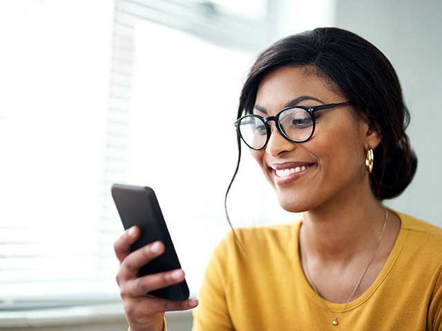 woman smiling at a cell phone