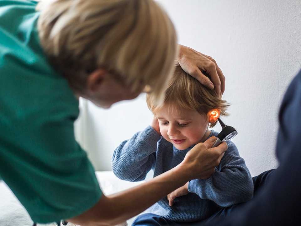 Healthcare provider checking child's ear.