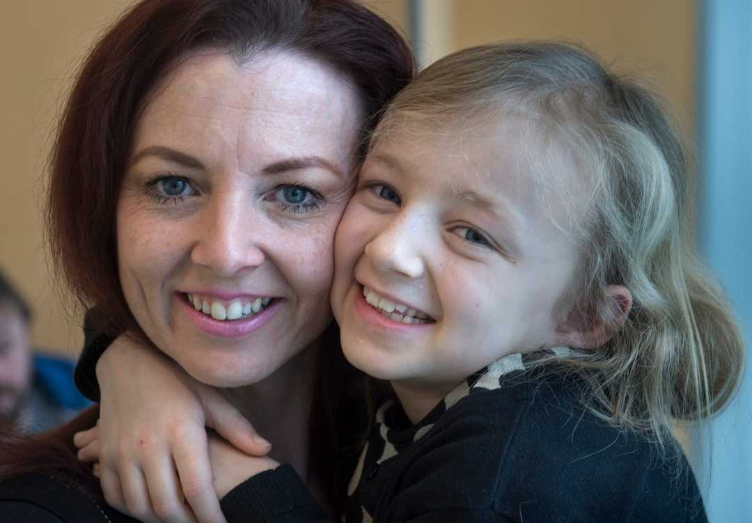 Mother smiling at young daughter.