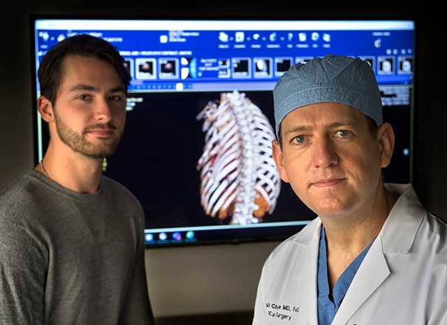 Two medical providers in front of diagnostic image.